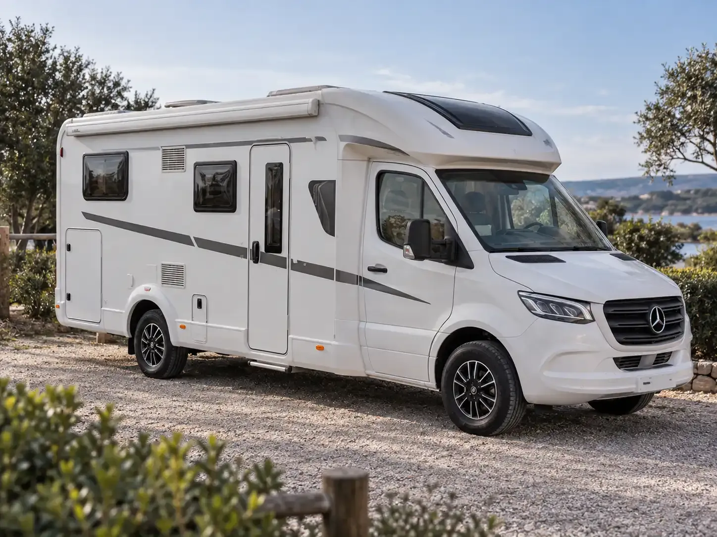 Camping-car avec porte de cellule fermée, sur une aire au bord de l’eau