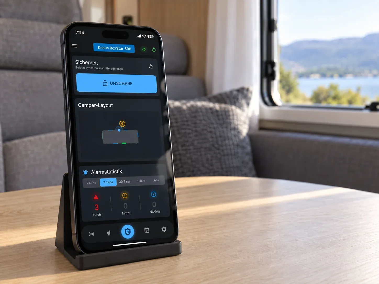 Smartphone affichant l’état du système CamperGuard, posé sur une table dans un camping-car